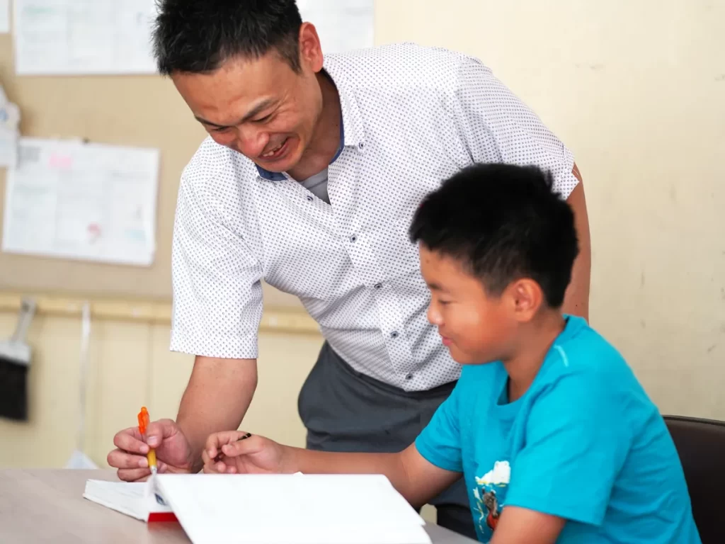 問題の解き方を教えてくれる先生と笑顔の生徒