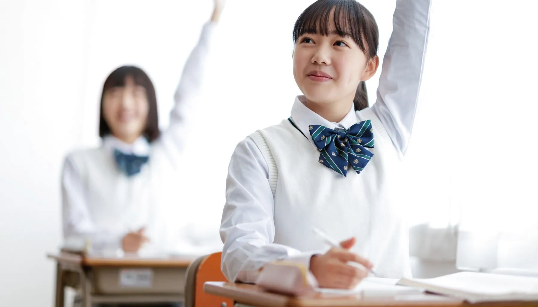 意欲的に授業参加する笑顔の女子生徒の写真